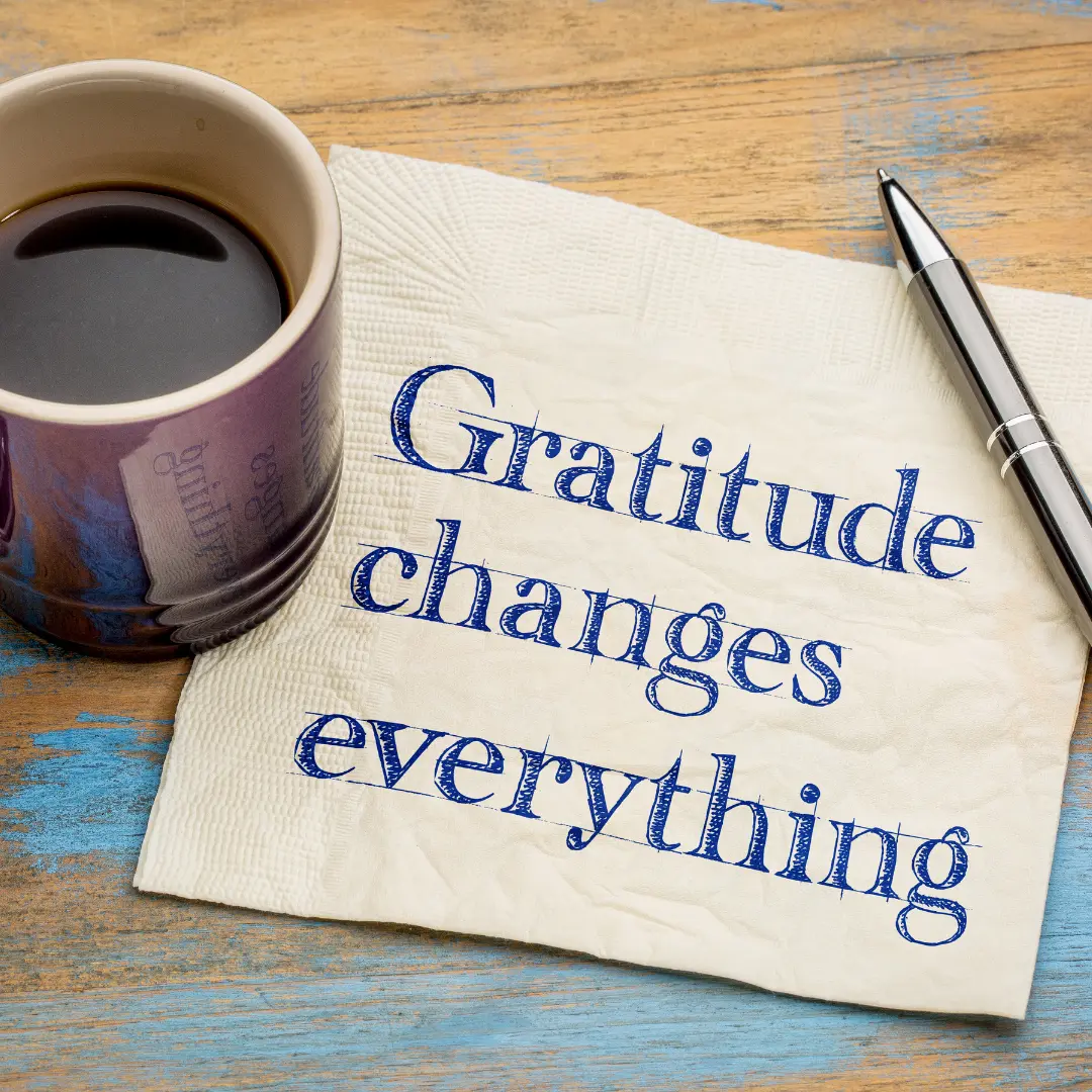 Une serviette où est écrit « Gratitude changes everything » à côté d'un café